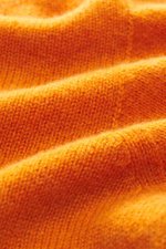 Nahaufnahme des orangefarbenen 04651/ A trip in a bag Cashmere Rundhalspullover 'Extreme Cashmere Crew' mit feinem, weichem Strick und Rippbündchen.