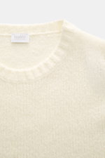 Nahaufnahme des 04651/ A trip in a bag Rundhalspullovers 'Molly Crew' creme von oben, zeigt weiche Bouclé-Struktur aus Merinowolle, Slim Fit und flexible Rippbündchen.