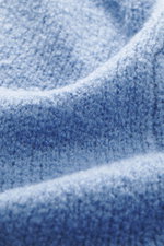 Nahaufnahme der weichen Bouclé-Struktur des 04651/ A trip in a bag Rundhalspullover 'Molly Crew' rauchblau, leichte Falten, mittelfeines Strickbild.