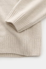 Nahaufnahme des 04651/ A trip in a bag Rundhalspullover sand, fotografiert von oben, zeigt weichen Merinowolle-Cashmere Mix, Slim Fit, feines Strickbild, Rippbündchen und seitliche Rippstrick-Details.