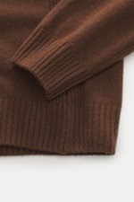 Alt-Tag (max. 125 Zeichen): Detailaufnahme des 04651/ A trip in a bag Rundhalspullover braun mit weichem Merinowolle-Cashmere-Mix, Rippbündchen aus seitlicher Perspektive.