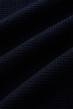 Close-up front view of Stone Island Strickpolo navy showing finely structured knit, pure cotton texture, and navy color with a subtle pattern. Style trifft auf lässigen Komfort: Dieses Strickpolo überzeugt mit fein strukturiertem Strick aus reiner Baumwol