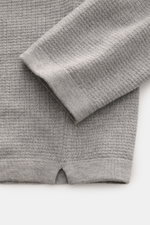 Close-up front view of Stone Island Strickpolo grau showing finely textured pure cotton knit, ribbed cuffs, double-stitched hem, and side slit for casual comfort. Style trifft auf lässigen Komfort: Dieses Strickpolo überzeugt mit fein strukturiertem Stric