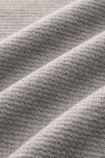 Close-up front view of Stone Island Strickpolo grau showing finely textured gray knit fabric with a slightly grainy feel, made of pure cotton. Style trifft auf lässigen Komfort: Dieses Strickpolo überzeugt mit fein strukturiertem Strick aus reiner Baumwol