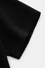 Stone Island Kurzarm-Strickpolo schwarz, Nahaufnahme des Ärmels mit feinem Piqué-Mix, Regular Fit, Polokragen, Weblabel, Saumschlitzen und doppelt gearbeiteten Saumabschlüssen.