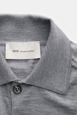 Close-up shot of the collar and top button of the Ami Paris Merino cardigan grey mottled, showing knit fabric texture and label.

<p>Timelessly elegant: The AMI PARIS cardigan, with its knit turn-down collar and pure merino wool fabric, is a comfortable c