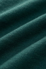 Nahaufnahme des von Braun Merino Feinstrickpolo dunkelgrün aus reiner Merinowolle, feines Strickbild, glatter Griff, Slim Fit, schmaler Polokragen.