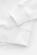 Weißes Polo Ralph Lauren Sweatshirt im Oversized Fit, Detailaufnahme von Ärmel und Saum, weicher Griff, Baumwoll-Microfaser-Mix, Rippbündchen.