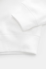 Weißes Polo Ralph Lauren Sweatshirt im Oversized Fit, Detailaufnahme Rippbündchen und weicher Baumwoll-Microfaser-Mix, seitliche Perspektive.