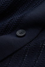 Close-up front view of the navy 04651/ A trip in a bag Short sleeve knit shirt narrow collar navy showing textured knit, button, and ribbed details.

<p>Summery ease: With a casual cut and comfortable cotton, this short sleeve knit shirt by 04651/ A TRIP 