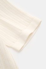 Nahaufnahme des Ärmels des 04651/ A trip in a bag Kurzarm-Strickhemd schmaler Kragen creme aus Baumwolle, Slim Fit mit Rippbündchen, Saumschlitz, Strukturstrick und glatter Knopfleiste, fotografiert von schräg oben.