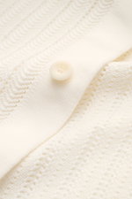 Nahaufnahme des 04651/ A trip in a bag Kurzarm-Strickhemd schmaler Kragen creme mit Strukturstrick, Knopf und glatter Knopfleiste aus reiner Baumwolle.