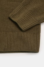 C.P. Company Strickpolo oliv aus Baumwoll-Chenille, Detailfoto von Ärmel und Saum mit mittelfeinem Strickbild, Rippbündchen, Linsen-Detail.