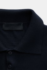 Nahaufnahme des Stone Island Strickpolo 'Ghost Pure Light Wool' navy mit klassischem Umlegekragen, feinem Strickbild und Label innen, von oben fotografiert.