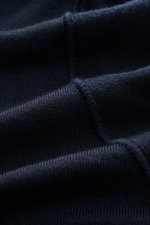 Stone Island Strickpolo 'Ghost Pure Light Wool' navy in Nahaufnahme, feines Strickbild, weicher Griff, reine Wolle, Rippbündchen sichtbar.