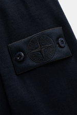 Nahaufnahme des Stone Island Strickpolo 'Ghost Pure Light Wool' navy, Detailansicht des Kompass-Badges aus reiner Wolle mit feinem Strickbild.