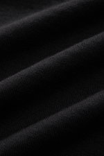 Stone Island Strickpolo 'Ghost Pure Light Wool' schwarz, Nahaufnahme des feinen Strickbilds aus reiner Wolle mit weichem Griff, Detail von Rippbündchen.