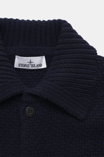 Nahaufnahme des Umlegekragens und der Fünf-Knopf-Leiste des Stone Island Cardigan navy aus Schurwolle und Microfaser, mit kernigem Griff, voluminösem Strickbild, Regular Fit, komfortablen Ärmelbündchen und Kompass-Badge am Oberarm.