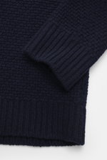 Nahaufnahme des Stone Island Cardigan navy, Perspektive auf Ärmelbündchen, voluminöses Strickbild, Mix aus Schurwolle und Microfaser.