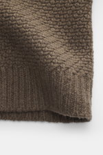 Nahaufnahme des Stone Island Cardigan braun aus schurwolle und microfaser, voluminöses Strickbild, Regular Fit, fünf-Knopf-Leiste, Umlegekragen, Ärmelbündchen, Kompass-Badge, leicht kerniger Griff, seitliche Perspektive.