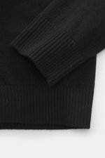 Nahaufnahme des schwarzen Stone Island Strickpolo in Regular Fit, Perspektive auf elastisches Bündchen aus reiner Schurwolle mit feinem Strickbild.