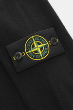 Stone Island Strickpolo schwarz in Nahaufnahme von oben, reine Schurwolle, feines Strickbild, weiche Qualität, Regular Fit, gestrickter Polokragen, Zwei-Knopf-Leiste, STONE ISLAND-Weblabel, elastische Bündchen.