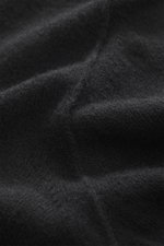 Stone Island Strickpolo schwarz, Nahaufnahme aus schräger Perspektive, reine Schurwolle, feines Strickbild, weiche Qualität, Regular Fit, gestrickter Polokragen, Zwei-Knopf-Leiste, STONE ISLAND-Weblabel, elastische Bündchen.