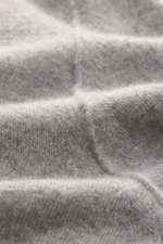 Nahaufnahme des Stone Island Strickpolo grau meliert, reine Schurwolle, feines Strickbild, weiche Qualität, Regular Fit, gestrickter Polokragen, Zwei-Knopf-Leiste, STONE ISLAND-Weblabel, elastische Bündchen.