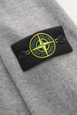 Nahaufnahme des Stone Island Strickpolo grau meliert von schräg oben, reine Schurwolle, feines Strickbild, weiche Qualität, Regular Fit, gestrickter Polokragen, Zwei-Knopf-Leiste, STONE ISLAND-Weblabel, elastische Bündchen.