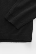 Emporio Armani Strickpolo schwarz, Nahaufnahme von Ärmel und Bund, Mix aus Schurwolle und Microfaser, elastisch, weicher Griff, feines Strickbild, Regular Fit, Polokragen mit Zipper, flexible Rippbündchen, tonales Logo-Stitching.
