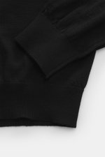 Malo Feinstrickpolo schwarz, Detailaufnahme von Ärmel und Bund, reine Schurwolle, weicher Griff, sehr feines Strickbild, Regular Fit, typischer Polokragen, Drei-Knopf-Leiste, komfortable Rippbündchen.