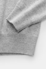 Nahaufnahme des Ärmelbunds und unteren Bereichs vom Fioroni Cashmere Strickpolo grau meliert, feines Strickbild, weicher Griff, reine Baby-Cashmere Qualität.