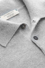 Fioroni Cashmere Strickpolo grau meliert, Nahaufnahme von Polokragen, drei Knöpfen und weichem, feinem Strickbild aus reinem Baby-Cashmere.