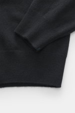 Nahaufnahme des Armbündchens und Saums vom Fioroni Cashmere Strickpolo schwarz, reine Baby-Cashmere Qualität, sehr feines Strickbild.