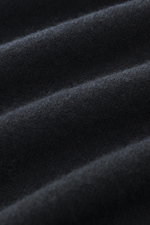 Nahaufnahme des schwarzen Fioroni Cashmere Strickpolos aus reinem Baby-Cashmere, zeigt weiche, feine Strickstruktur und leichte Falten aus frontaler Perspektive.
