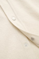 Nahaufnahme des B.F. Knitwear Cashmere Strickhemd Kent-Kragen creme mit feinem Strickbild und Druckknopfleiste, seitliche Perspektive.