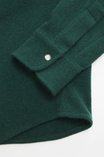 Close-up front angled view of B.F. Knitwear Cashmere knit shirt Kent collar dark green, showing fine knit, barrel cuffs with snap button.

Description: 
<p>A high-quality all-rounder for cool days: This knit shirt from B.F. KNITWEAR made of pure cashmere 