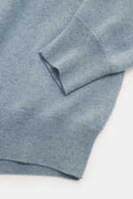 Nahaufnahme des Ärmels und Bunds vom Colombo Cashmere Strickpolo rauchblau meliert mit feinem Strickbild, Slim Fit und weichem Griff.