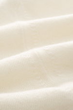 Della Ciana Troyer creme, seitliche Nahaufnahme, Mix aus Cashmere und Merinowolle, weicher Griff, feines Strickbild, Regular Fit, Troyer-Kragen mit Reißverschluss, flexible Rippbündchen