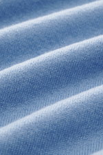 Nahaufnahme des feinen Strickbildes des Della Ciana Troyer hellblau aus Cashmere und Merinowolle mit weichem Griff, Regular Fit, Troyer-Kragen mit Reißverschluss und flexiblen Rippbündchen, fotografiert aus schräger Perspektive.