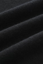 Nahaufnahme aus schräger Perspektive des feinen Strickbildes des Della Ciana Troyer schwarz mit weichem Griff, Mix aus Cashmere und Merinowolle.
