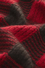 Nahaufnahme aus schräge Perspektive des Guest In Residence Strickpolo rot/dunkelbraun kariert mit mittelfeinem Strickbild, weichem Griff aus Wolle und Cashmere, Regular Fit, Drei-Knopf-Leiste, gestricktem Polokragen und komfortablen Rippbündchen.
