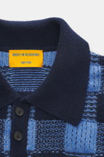 Nahaufnahme des Guest In Residence Strickpolo blau/navy kariert von oben, Mix aus Wolle und Cashmere, weicher Griff, mittelfeines Strickbild, Regular Fit, Drei-Knopf-Leiste, gestrickter Polokragen, komfortable Rippbündchen.
