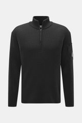 C.P. Company Troyer anthrazit in Frontansicht, mittelfeines Strickbild, Patent-Strickmuster, Slim Fit, Troyer-Kragen mit Reißverschluss, Tasche mit Zipper am Oberarm, Schurwolle/Microfaser, weicher Griff, flexible Rippbündchen, Linsen-Detail.