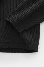 Nahaufnahme des C.P. Company Troyer anthrazit von schräg oben, zeigt mittelfeines Strickbild, weichen Griff, Patent-Strickmuster, flexible Rippbündchen.