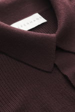 Nahaufnahme aus schräger Perspektive des Kiefermann Merino Strickpolo 'Imano' bordeaux mit feinem Strickbild, typischem Polokragen, Drei-Knopf-Leiste, Oversized Fit, weichem Griff aus reiner Merinowolle.