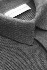 Nahaufnahme aus schräger Perspektive des Kiefermann Merino Strickpolo 'Imano' dunkelgrau mit typischem Polokragen, Drei-Knopf-Leiste, feinem Strickbild, Oversized Fit, weichem Griff aus reiner Merinowolle.
