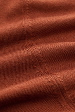 Close-up view of the rust brown fabric of the Gran Sasso Fine knit polo rust brown showing a very fine knit texture. Luxury you can feel on your skin: This long sleeve knit polo by BRAUN HAMBURG has an exceptionally soft feel and timeless elegance. The lu