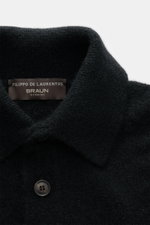 Nahaufnahme des schwarzen Filippo de Laurentiis Toyer mit Troyer-Kragen, mittelfeinem Strickbild, weichem Griff, Oversized Fit, flexiblen Rippbündchen, Mix aus Cashmere, Seide und Microfaser, fotografiert von oben.