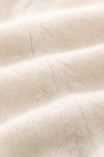 Nahaufnahme in leichter Schrägansicht des mittelfeinen Strickbilds vom Filippo de Laurentiis Toyer creme, Mix aus Cashmere, Seide und Microfaser, sehr weicher Griff, Oversized Fit, Troyer-Kragen, flexible Rippbündchen.